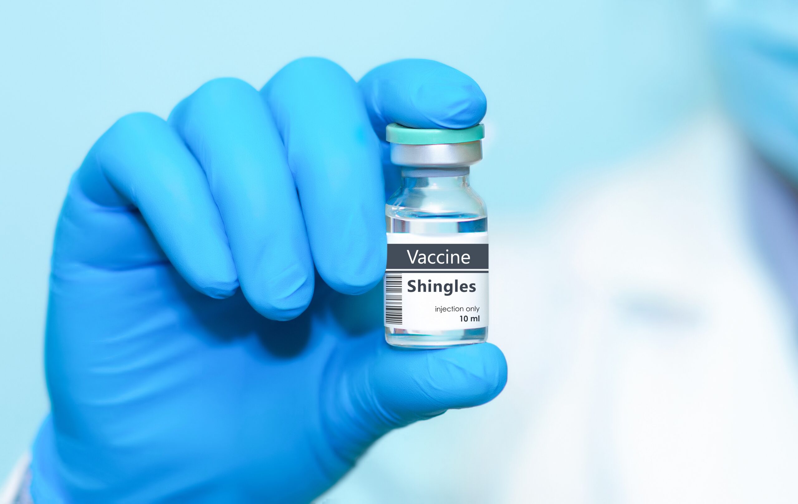 Doctor in protective gloves holding a shingles vaccine