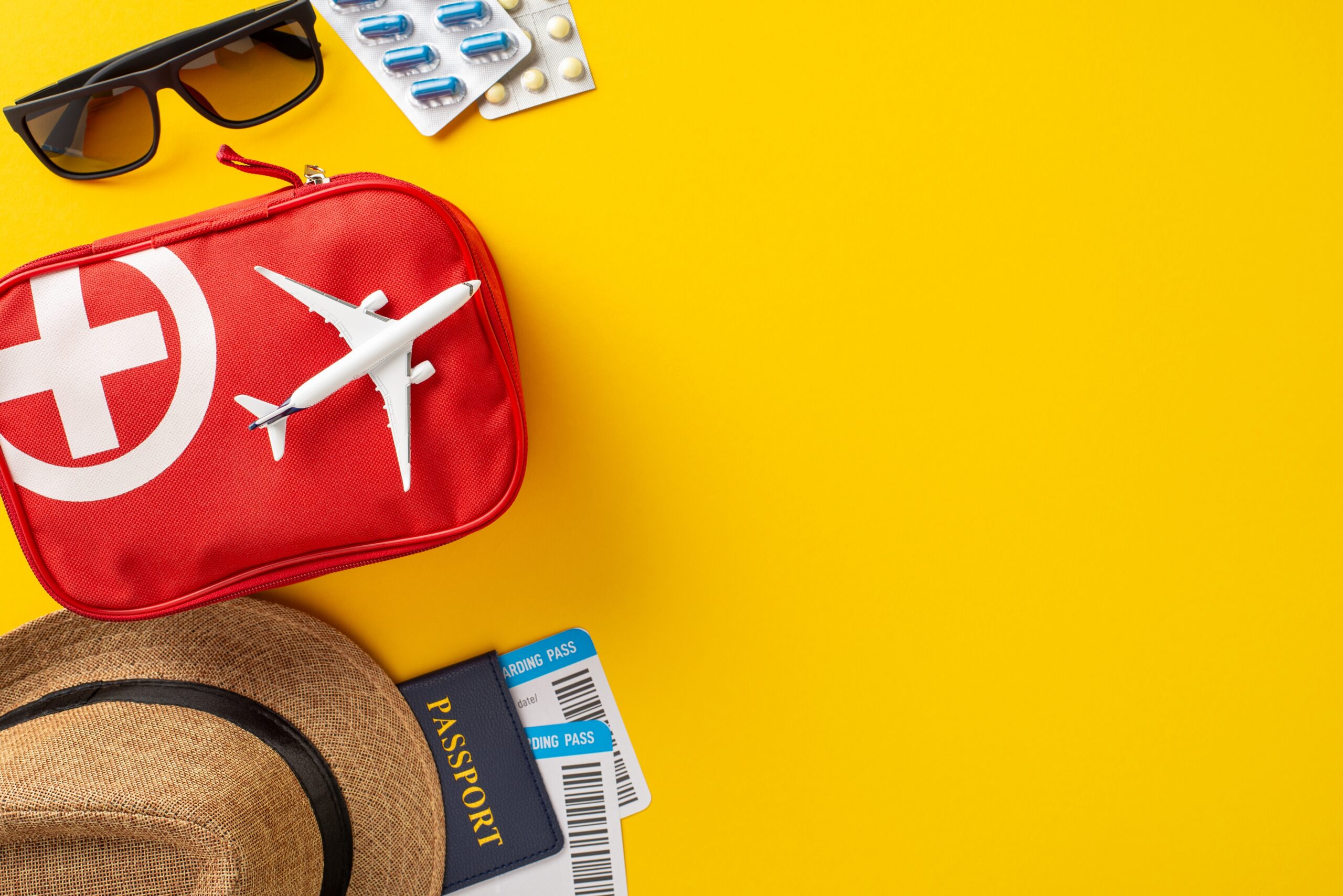 Travel health essentials arranged with passport against a vibrant yellow backdrop