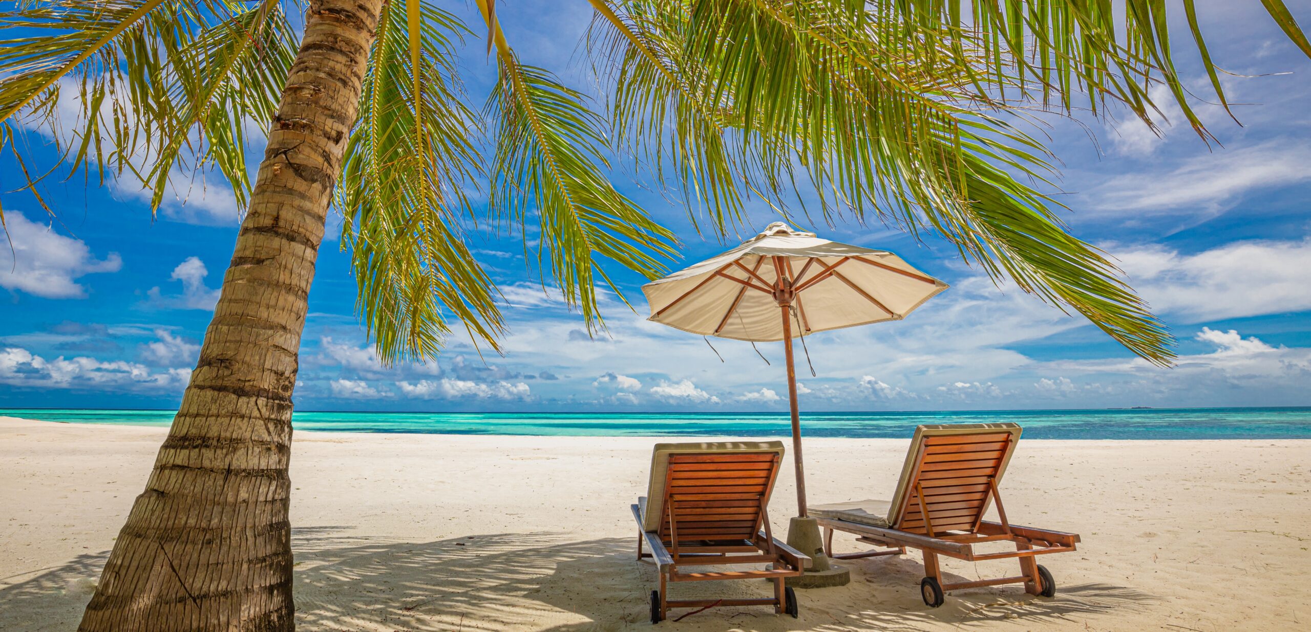Pair of chairs on beach with umbrella and sea view