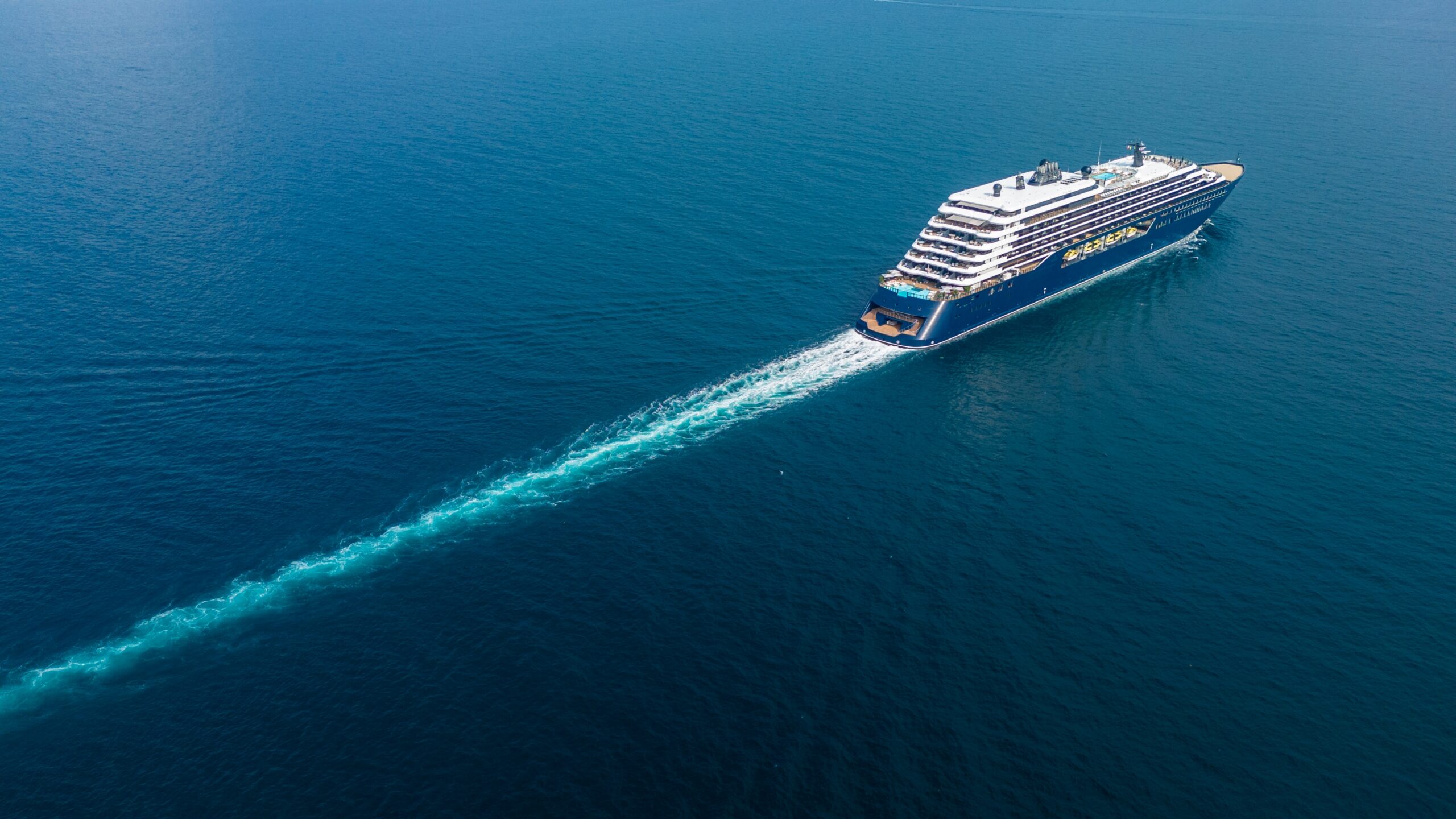 luxury cruise ship sailing across vast blue ocean leaving a white wake luxury cruise ship sailing across vast blue ocean leaving a white wake